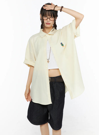 LEWKIN Oversized Button-Up Shirt CU530 Light yellow front shot on model size M/L hand raised to forehead open over white crop top with denim shorts