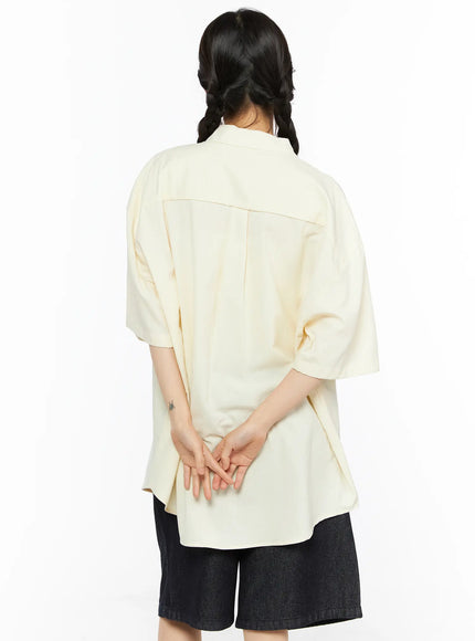 Oversized Button-Up Shirt CU530 Light yellow back shot on model hands clasped behind showing clean yoke seam curved hem and oversized drop-shoulder fit