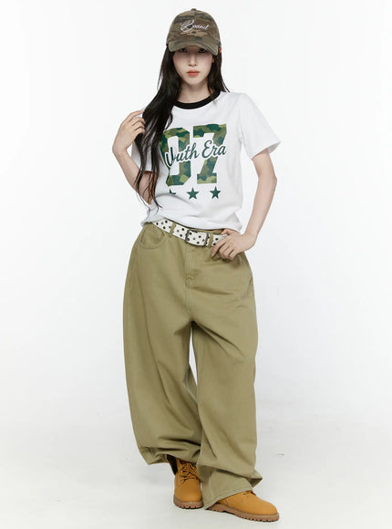 Oversized Cargo Pants IL522 Beige full-body front styled shot on model standing upright wearing graphic tee with studded belt and boots
