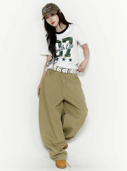 Oversized Cargo Pants IL522 Beige full-body styled shot on model wearing camo cap and graphic tee with studded belt and chunky boots