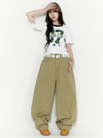 Oversized Cargo Pants IL522 Beige full-body styled shot on model in dynamic pose touching cap wearing graphic tee and studded belt