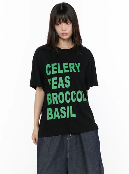 Oversized Graphic Tee CL522 Black front close-up on model showing CELERY PEAS BROCCOLI BASIL green bold graphic print crew neck