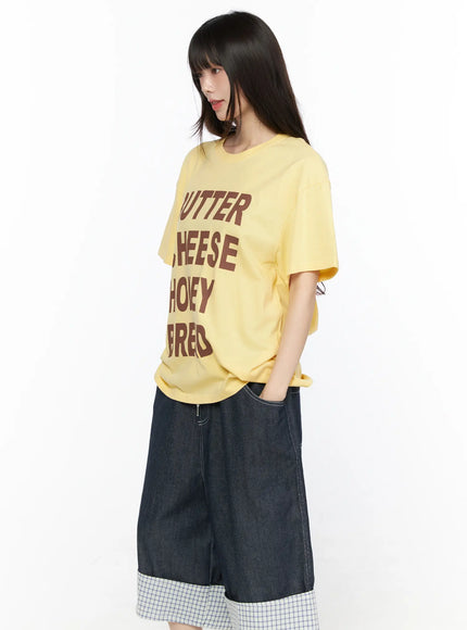 Oversized Graphic Tee CL522 Yellow angled front view on model showing BUTTER CHEESE HONEY BREAD brown graphic print and hem length