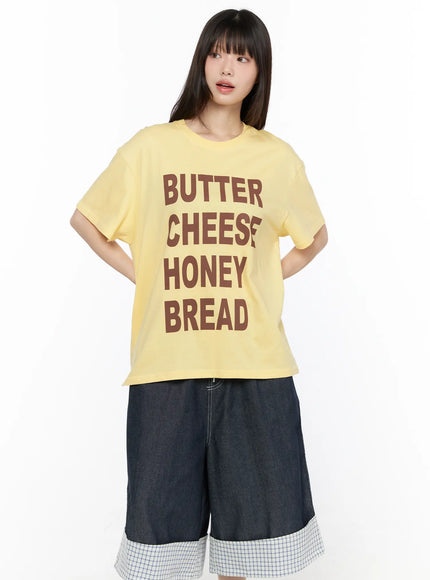 Oversized Graphic Tee CL522 Yellow front view on model hands behind back showing BUTTER CHEESE HONEY BREAD graphic oversized cotton tee