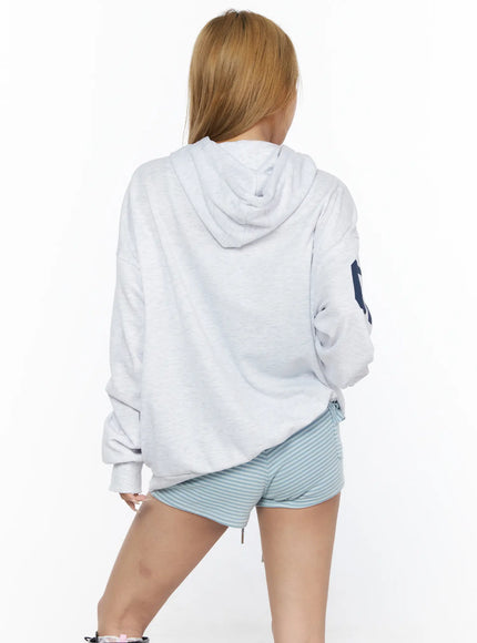Oversized Graphic Zip-Up Hoodie CL528 Light Gray back shot on model showing oversized hood dropped shoulders clean back panel and navy 07 sleeve print paired with striped shorts