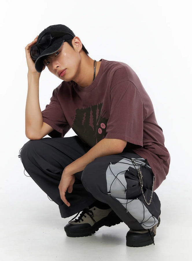 LEWKIN Oversized Kitty Graphic T-Shirt IL516 Wine Red front shot male model crouching wearing oversized tee with dark cat graphic print styled with cargo pants