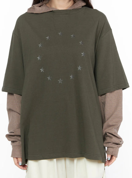 Oversized Layered Tee Striped Hoodie CL523 Dark green close-up front torso shot highlighting circular silver star embroidery pattern on cotton fabric with brown striped hood