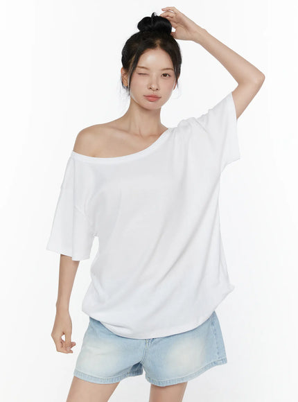 Oversized Off-Shoulder Tee CL520 White close-up front shot on model arm raised showing asymmetric off-shoulder neckline and oversized boxy cotton drape