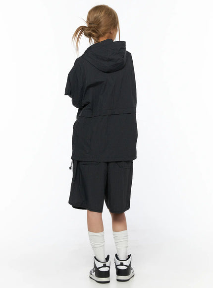 Oversized Plaid Windbreaker CU523 Black back shot model standing showing hood construction short sleeves layered hem and grid-check nylon fabric with matching shorts