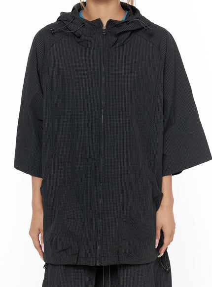 Oversized Plaid Windbreaker CU523 Black close-up detail shot showing grid-check nylon hem layering jacket over matching shorts with drawstring waistband and zip detail