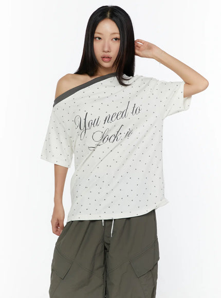 Oversized Polka Dot Off-Sholder Tee CU526 White half-body front shot model hand raised to hair displaying star allover print off-shoulder neckline and oversized boxy fit