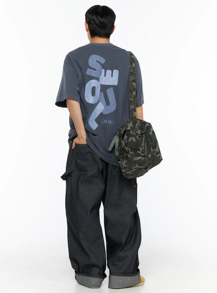 Oversized Seoul Graphic T-Shirt IL516 charcoal blue back full-body shot on male model with camo crossbody bag showing large SEOUL graphic and 서울 badge print