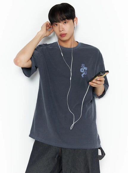Oversized Seoul Graphic T-Shirt IL516 charcoal blue front shot on male model holding phone with earphones small chest graphic print