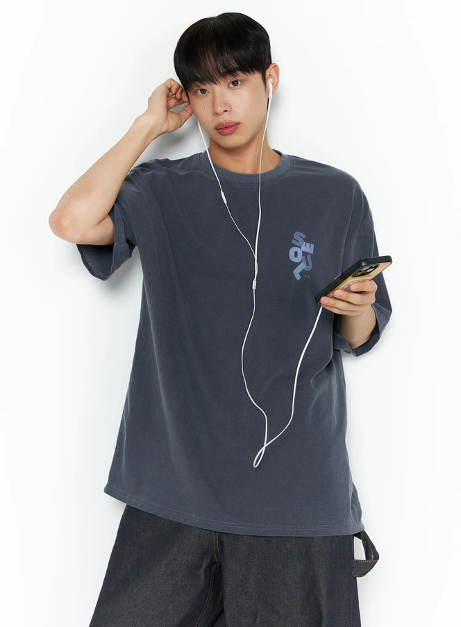Oversized Seoul Graphic T-Shirt IL516 charcoal blue front shot on male model holding phone with earphones small chest graphic print