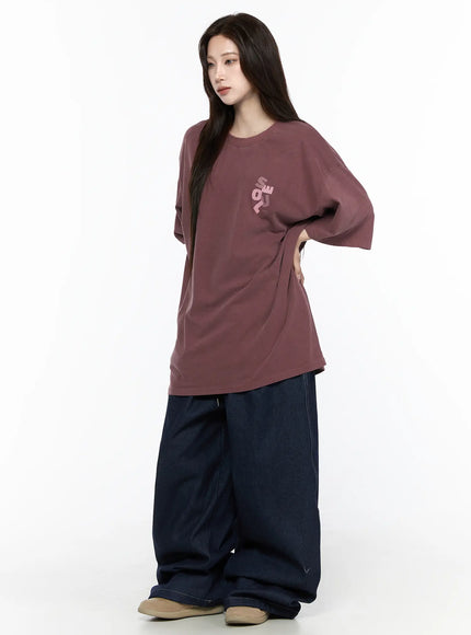 Oversized Seoul Graphic T-Shirt IL516 Dark red three-quarter front shot on female model looking down hand on hip chest SEOUL logo visible styled with wide-leg jeans