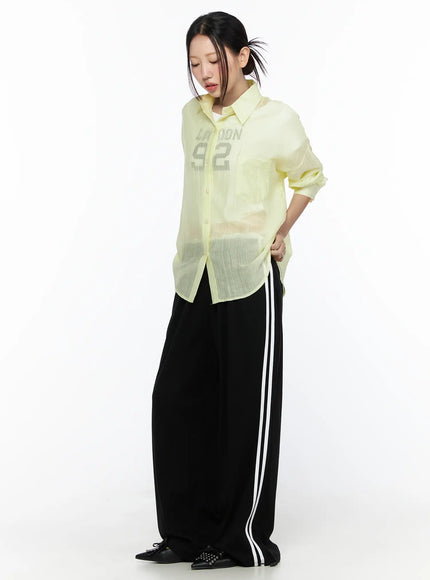 Oversized Sheer Shirt CL524 Yellow full-body front model shot, buttoned closed over graphic tee, styled with black stripe wide-leg pants