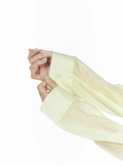 Oversized Sheer Shirt CL524 Yellow detail close-up of sleeve cuff and sheer crinkle fabric texture with button fastening, model hands visible