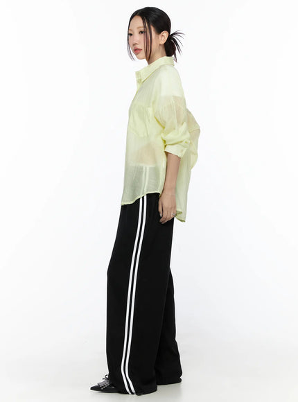 Oversized Sheer Shirt CL524 Yellow side model shot showing relaxed oversized silhouette, sheer crinkle fabric, rolled sleeves, hip length hem