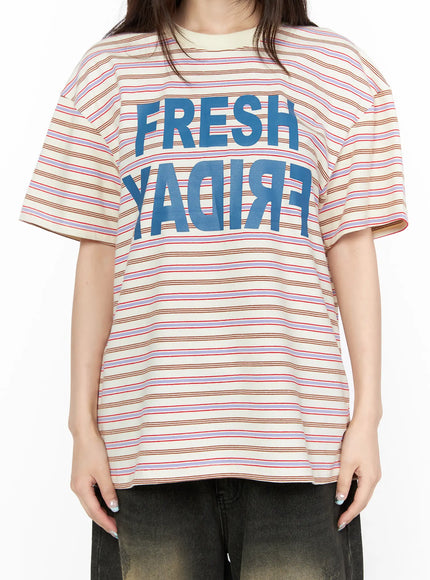 Oversized Striped Graphic Tee CL523 light beige close-up front torso detail shot highlighting FRESH FRIDAY blue mirrored graphic print on striped cotton