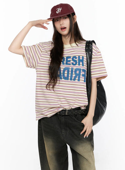 LEWKIN Oversized Striped Graphic Tee CL523 Light beige M/L front model styled shot with burgundy cap and black leather bag over wide-leg jeans