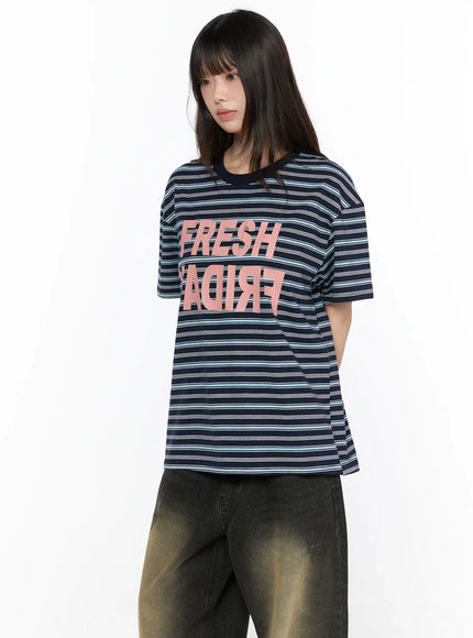 Oversized Striped Graphic Tee CL523 navy blue front model three-quarter shot with pink FRESH FRIDAY mirrored graphic print and dark striped cotton