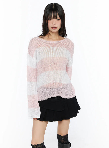 Oversized Striped Knit Sweater CU530 Pink cropped front shot on model showing wide stripe open-knit texture sheer fabric boat neckline and flared cuffs over black mini skirt