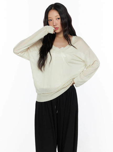 Oversized Summer Sheer V-Neck Long Sleeve Top CL513 Beige front model shot hand raised to face showcasing lace V-neckline trim and relaxed oversized silhouette