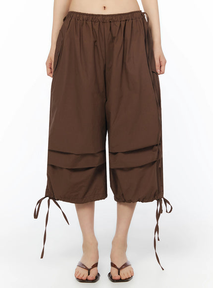 LEWKIN Parachute Cargo Shorts IU525 Brown front close-up on model showing elastic waistband, wide-leg silhouette, and ribbon tie hem detail
