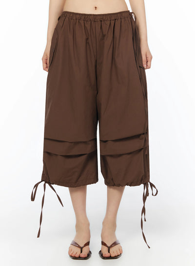 LEWKIN Parachute Cargo Shorts IU525 Brown front close-up on model showing elastic waistband, wide-leg silhouette, and ribbon tie hem detail
