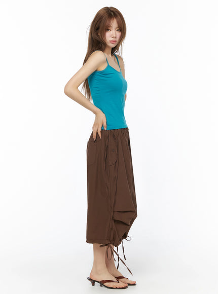 Parachute Cargo Shorts IU525 Brown side view on model in teal cami top showing side pocket, button closure, drawstring, and cascading tiered hem