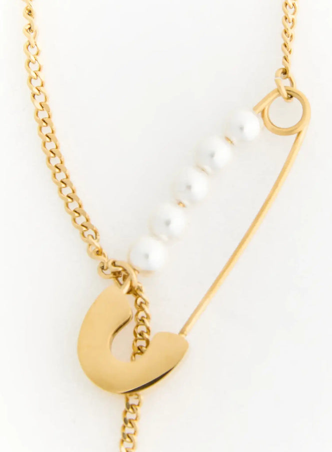 Pearl Safety Pin Necklace IL522 Gold close-up detail of safety pin clasp with row of white pearls and gold curb chain on white background