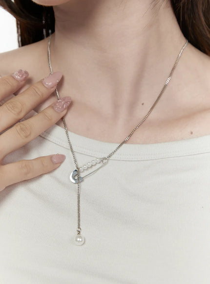 LEWKIN Pearl Safety Pin Necklace IL522 Silver front view on model wearing white top, safety pin pendant with pearl row and single drop pearl on curb chain