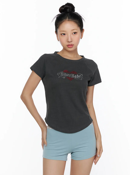Pigment Cap Sleeve Tee CL510 Dark gray front model half-body shot without accessories showing rhinestone BikerBabe heart motif curved hem and raglan cap sleeves