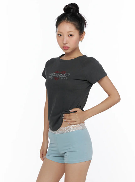 Pigment Cap Sleeve Tee CL510 Dark gray side model shot hand on waist showing slim fit silhouette curved hem and rhinestone graphic with lace-waist shorts