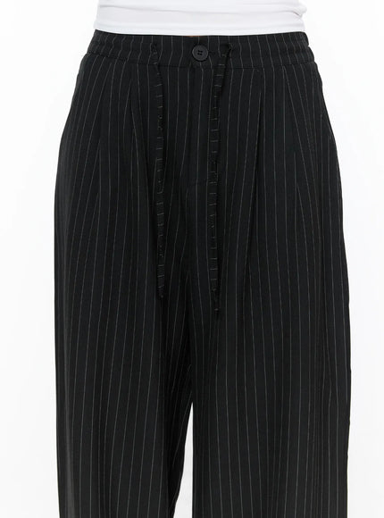 Pinstripe Wide Leg Trousers CL513 Black close-up detail shot showing waistband button closure pleated fly and white pinstripe woven fabric texture