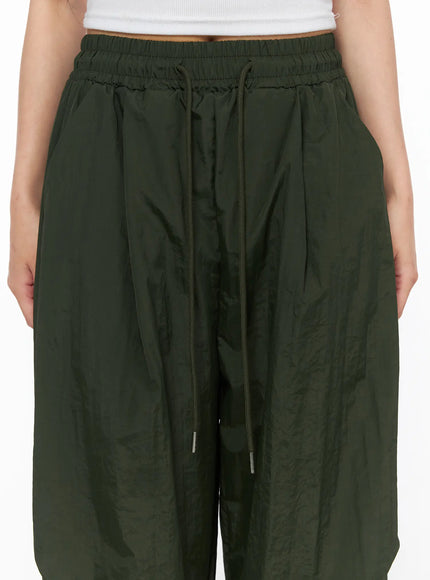 Pintuck Nylon Wide Pants CL514 Dark green close-up detail of elastic waistband and drawstring cord with metal aglets showing pintuck pleats