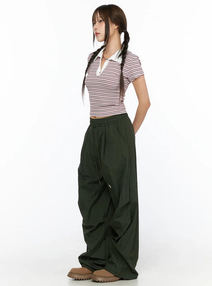 Pintuck Nylon Wide Pants CL514 Dark green side full-length view on model with twin braids paired with striped polo crop top showing gathered hem