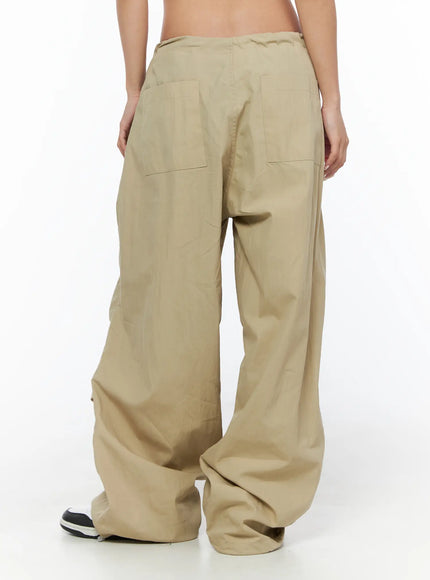 Pintuck Pocket Parachute Pants CU524 Beige back shot on model showing two large patch back pockets low rise waistband and pooling hem