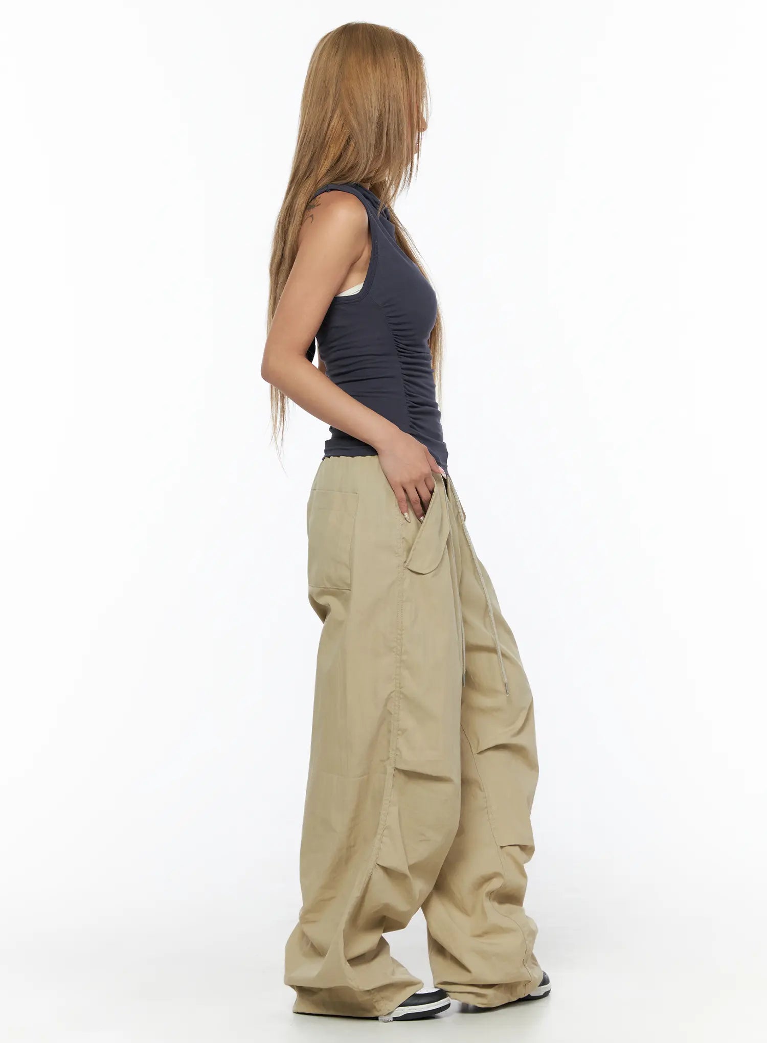Pintuck Pocket Parachute Pants CU524 Beige side full-body shot on model with hand in pocket highlighting side cargo pocket and parachute nylon volume