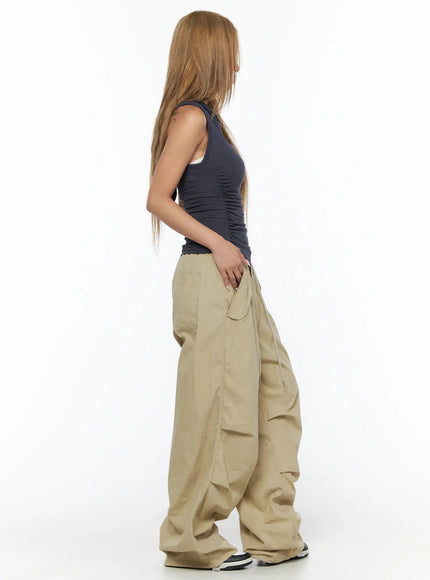 Pintuck Pocket Parachute Pants CU524 Beige side full-body shot on model with hand in pocket highlighting side cargo pocket and parachute nylon volume