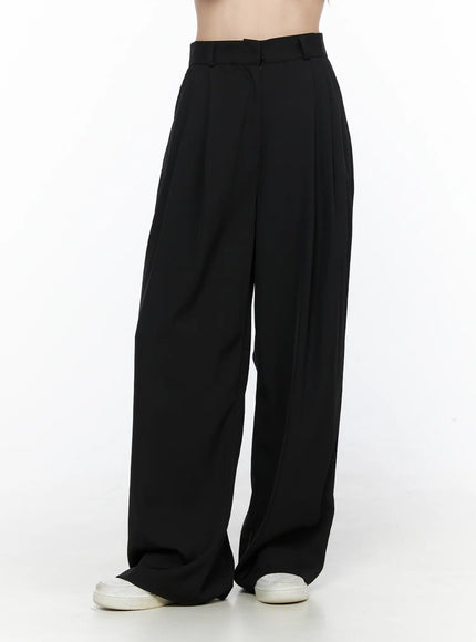 Pintuck Wide Leg Pants (Black) CL524 Black three-quarter front shot on model showing pleated high waist panel and wide leg silhouette with white sneakers