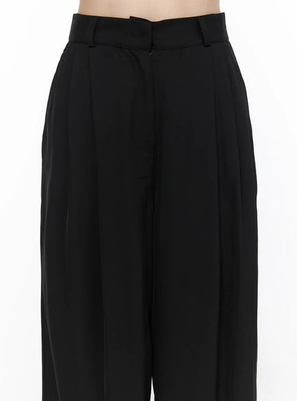 Pintuck Wide Leg Pants (Black) CL524 Black close-up front detail shot on model highlighting high waist belt loops asymmetric waistband and pintuck pleats