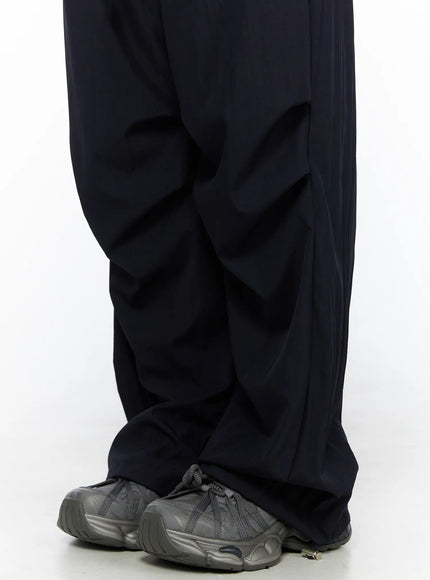 Pintuck Wide Leg Pants CL527 Dark blue close-up detail of wide-leg hem and ankle cinch toggle over chunky gray sneakers, lower leg detail shot