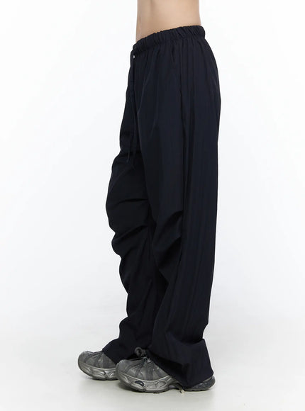 Pintuck Wide Leg Pants CL527 Dark blue side view on model showing ruched pintuck detailing along thigh and wide-leg hem pooling over sneakers