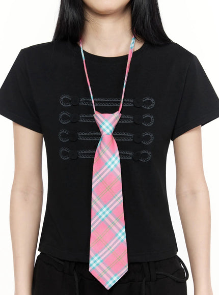 LEWKIN Plaid Adjustable Tie IL516 Pink One Size close-up on model torso showing pink teal plaid woven tie with pre-tied knot over black military embroidered tee