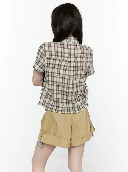 Plaid Button-Up Shirt IL521 Beige side shot on model with straight long hair, three-quarter angle showing cropped fit and short cuffed sleeves of plaid button-up, styled with khaki shorts