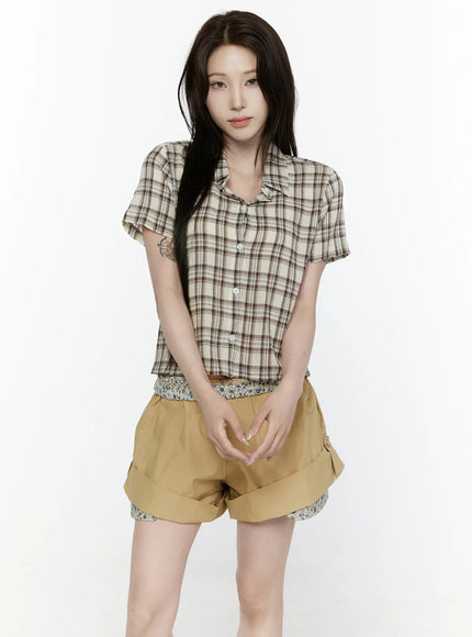 Plaid Button-Up Shirt IL521 Beige close-up front detail shot on model, showing open notch collar, white button placket, and brown plaid woven texture, layered over floral base top