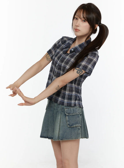 Plaid Crop Short Sleeve Shirt CL507 Navy blue side shot on model with arms extended showing cropped silhouette short sleeves and plaid pattern styled with denim skirt