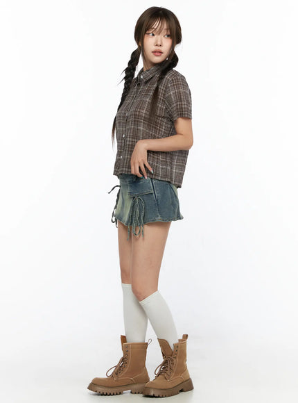 Plaid Crop Short Sleeve Shirt CL514 Brown full-body side shot on model in profile pose showing cropped hem and plaid texture paired with denim mini skirt and boots