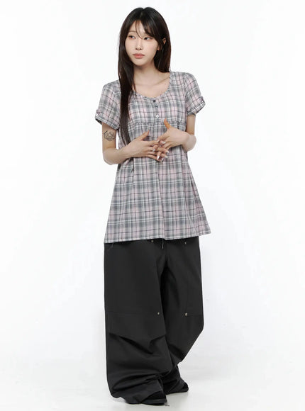 Plaid Cuffed Sleeve Babydoll Dress IL502 Pink full-body front shot on model with hands clasped at waist, styled with black wide-leg pants in clean studio setting